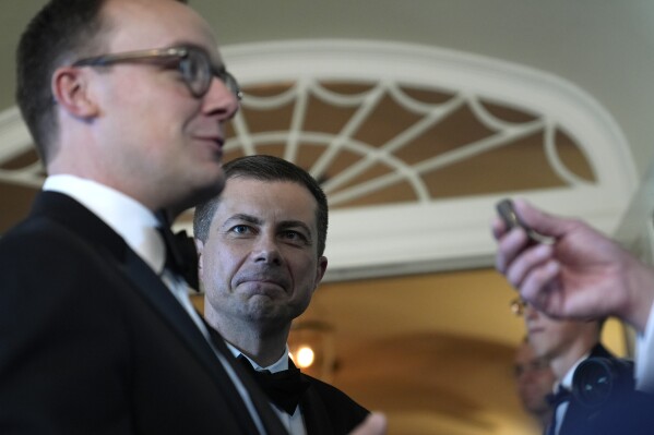Transportation Secretary Pete Buttigieg, right, listens as his husband Chasten Buttigieg, left, talks with the reporter as they arrive for a state dinner at the White House in Washington, Thursday, May 2, 2024, to honoring the 2024 National Teacher of the Year and other teachers from across the United States.  (AP Photo/Susan Walsh)