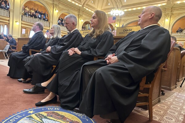 Justices of the South Dakota Supreme Court listen to Gov. Kristi Noem's State of the State address on Tuesday, Jan. 9, 2024, in the House of Representatives at the state Capitol in Pierre, S.D. The court on Friday, Feb. 9, 2024, issued an opinion regarding legislator conflicts of interest related to state contracts, which Noem requested last fall after a state senator resigned her seat and agreed to pay back about $500,000 of federal coronavirus aid she had received for her preschool business. (AP Photo/Jack Dura Jack)