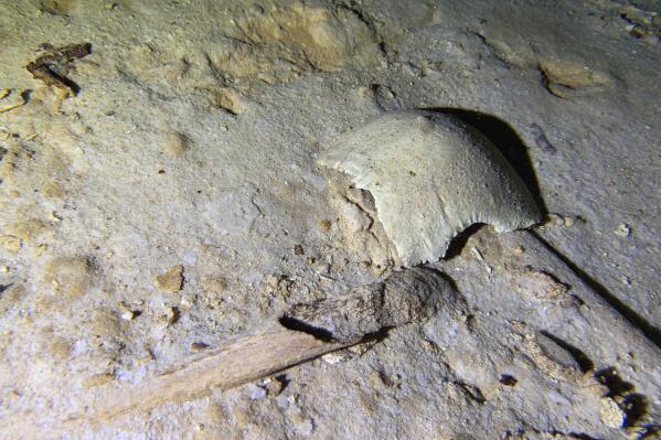 In this photo courtesy of Octavio del Rio, shows fragments of a pre-historic human skeleton partly covered by sediment in an underwater cave in Tulum, Mexico, Sept. 10, 2022. The cave system was flooded at the end of the last ice age 8,000 years ago, according to an archaeologist and cave diver Octavio del Rio, and is located near where the government plans to build a high-speed tourist train through the jungle. (Octavio del Rio via AP)