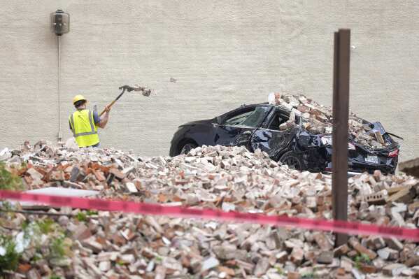 A worker digs out bricks from a collapsed wall near Commerce and Main Street downtown on Friday, May 17, 2024, in Houston, after a strong thunderstorm moved through Thursday evening. (Karen Warren/Houston Chronicle via Ǻ)