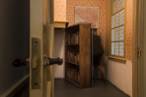 FILE - A woman enters the secret annex at the renovated Anne Frank House Museum in Amsterdam, Netherlands, Wednesday, Nov. 21, 2018. A court in Amsterdam sentenced a Polish-Canadian national to two months in prison on Thursday, Oct. 19, 2023 for projecting a message alluding to an antisemitic conspiracy theory onto the Anne Frank House museum. (AP Photo/Peter Dejong, File)