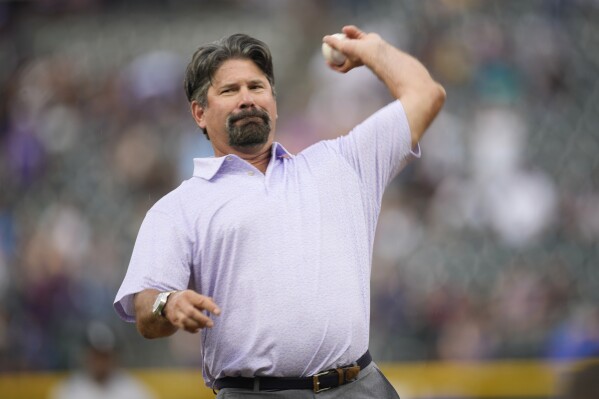 Retired Colorado Rockies first baseman Todd Helton thorws out the ceremonial first pitch before the team's baseball game against the Chicago White Sox on Saturday, Aug. 19, 2023, in Denver. (AP Photo/David Zalubowski)