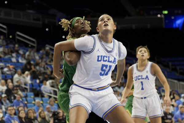 UCLA center Lauren Betts (51) fights for position with Oregon center Phillipina Kyei, left, during the first half of an NCAA basketball game in Los Angeles, Friday, Jan. 5, 2024. (AP Photo/Jae C. Hong)