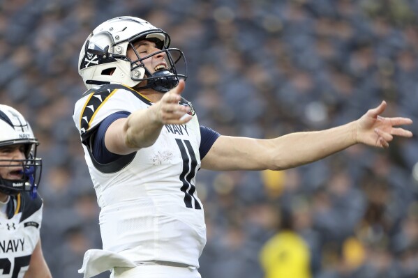 Navy quarterback Blake Horvath (11) celebrates after scoring a touchdown during the first half of an NCAA college football game against Army, Saturday, Dec. 14, 2024, in Landover, Md. (AP Photo/Daniel Kucin Jr.)