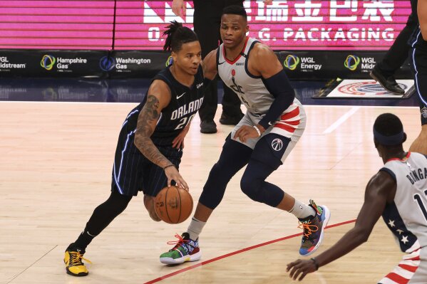 Orlando Magic guard Markelle Fultz (20) drives to the basket past Washington Wizards guard Russell Westbrook (4) in the third quarter of an NBA basketball game Saturday, Dec. 26, 2020, in Washington. (Geoff Burke/Pool Photo via AP)