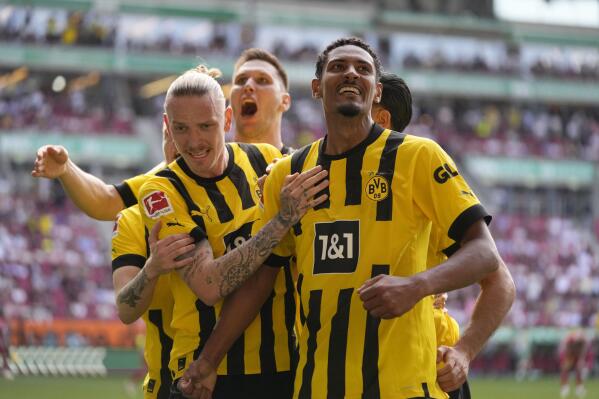 Borussia Dortmund players celebrate after Dortmund's Sebastien Haller, right, scored his side's second goal during the German Bundesliga soccer match between FC Augsburg and Borussia Dortmund at the WWK Arena in Augsburg, Germany, Sunday, May 21, 2023. (AP Photo/Matthias Schrader)