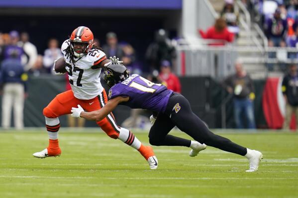 Cleveland Browns running back Kareem Hunt (27) tries to escape from Baltimore Ravens safety Kyle Hamilton (14) after a catch in the first second of an NFL football game, Sunday, Oct. 23, 2022, in Baltimore. (AP Photo/Julio Cortez)