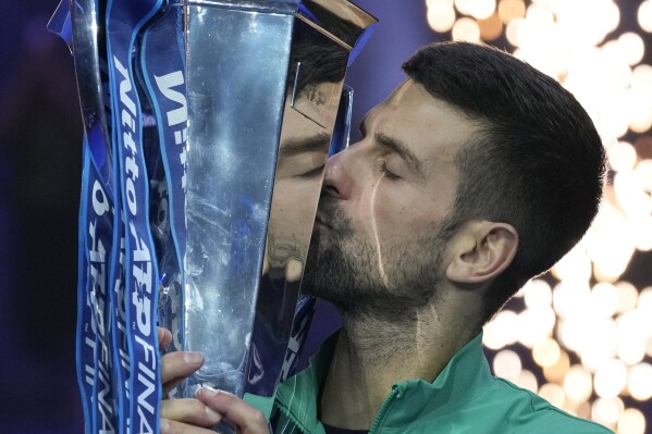 Serbia's Novak Djokovic kisses the trophy after winning the singles final tennis match of the ATP World Tour Finals at the Pala Alpitour, in Turin, Italy, Sunday, Nov. 19, 2023. (AP Photo/Antonio Calanni)