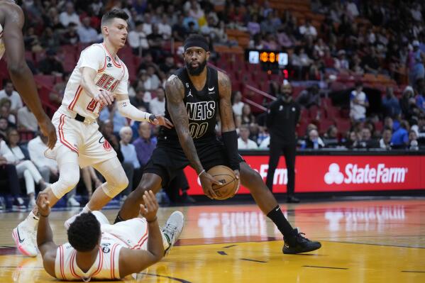 Brooklyn Nets forward Royce O'Neale (00) looks for an opening past Miami Heat guards Tyler Herro, left, and Kyle Lowry, during the first half of an NBA basketball game, Sunday, Jan. 8, 2023, in Miami. (AP Photo/Wilfredo Lee)