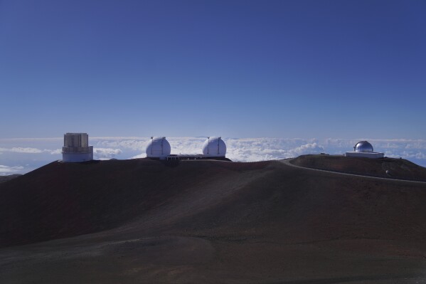 From left, Subaru Telescope, W.M. Keck Observatory, and the NASA Infrared Telescope Facility sit on the summit of Mauna Kea in Hawaii, on Saturday, July 15, 2023. Over the last 50 years, astronomers have mounted 13 giant telescopes on Mauna Kea's summit. In 2009, they proposed an even larger Thirty Meter Telescope, which spurred lawsuits and protests by Native Hawaiian activists. (AP Photo/Jessie Wardarski)