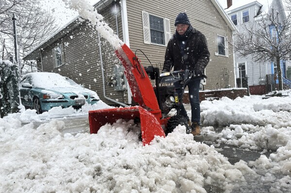 FILE - Phil Cloutier removes heavy, wet snow after an early-spring Nor'easter, Thursday, April 4, 2024, in Portland, Maine. The federal government has declared a powerful late-season snow storm that caused millions of dollars in damage in Maine to be a major disaster. (AP Photo/David Sharp, File)