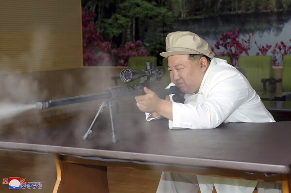 In this undated photo provided by the North Korean government, North Korean leader Kim Jong Un tries a weapon during his three-day inspection from Aug. 3 until Aug. 5, 2023 at major munitions factories in North Korea. Independent journalists were not given access to cover the event depicted in this image distributed by the North Korean government. The content of this image is as provided and cannot be independently verified. Korean language watermark on image as provided by source reads: 