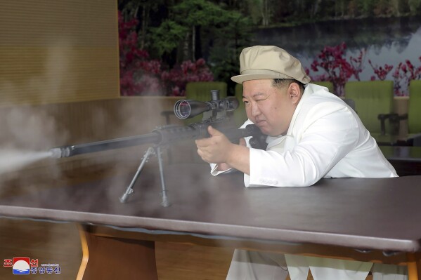 In this undated photo provided by the North Korean government, North Korean leader Kim Jong Un tries a weapon during his three-day inspection from Aug. 3 until Aug. 5, 2023 at major munitions factories in North Korea. Independent journalists were not given access to cover the event depicted in this image distributed by the North Korean government. The content of this image is as provided and cannot be independently verified. Korean language watermark on image as provided by source reads: "KCNA" which is the abbreviation for Korean Central News Agency. (Korean Central News Agency/Korea News Service via AP)