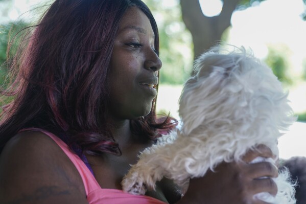 Nikuya Brooks holds her dog Snowball at home Friday, Aug. 11, 2023, in Chicago. Brooks' bond was set at $150,000 after her first-time arrest on drug charges in 2017, according to the mother of three. No one in her family could pull together 10% of the bond for her to walk free. Illinois will become the first state to completely abolish cash bail on Sept. 18, making the state a testing ground for whether and how eliminating it works on a large scale. (AP Photo Erin Hooley)
