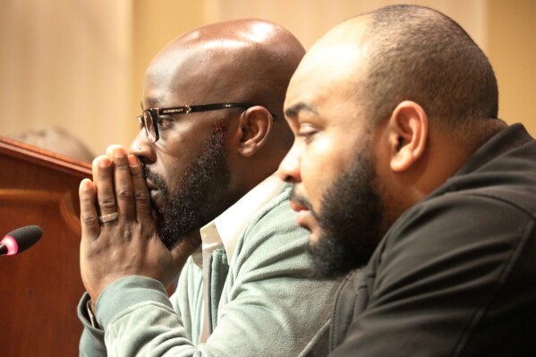 Eric Simmons, left, and Demetrius Smith, who were found innocent after spending years in prison for crimes they did not commit in Maryland, testify before state lawmakers for legislation to address how the wrongly incarcerated should be compensated by the state during a hearing Wednesday, Feb. 26, 2020 in Annapolis, Md. On Wednesday, Sept. 20, 2023, a Maryland board approved more than $340,000 for a settlement to compensate Smith, who was wrongly convicted of murder and assault in two separate cases and spent more than five years in prison. (AP Photo/Brian Witte, File)