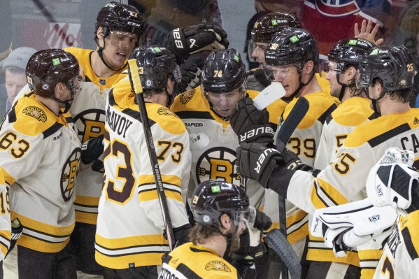 Boston Bruins' Jake DeBrusk, center, celebrates after his winning goal over the Montreal Canadiens with teammates following overtime NHL hockey action in Montreal, Thursday, March 14, 2024. (Christinne Muschi/The Canadian Press via AP)