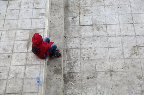 A child recently expelled from the U.S. after trying to seek asylum sits next to the international bridge in the Mexican border city of Reynosa, Saturday, March 27, 2021. Dozens of migrants who earlier tried to cross into the U.S. in order to seek asylum have been expelled from the U.S. under pandemic-related presidential authority. (AP Photo/Dario Lopez-Mills)
