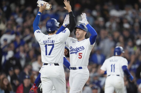 Los Angeles Dodgers' Freddie Freeman (5) celebrates after his grand slam with teammate Shohei Ohtani (17) during the third inning of a baseball game against the Arizona Diamondbacks, Monday, May 20, 2024, in Los Angeles. (AP Photo/Marcio Jose Sanchez)