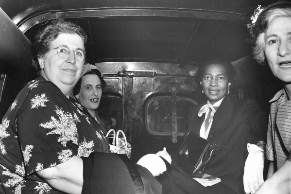 FILE - Communist Party members from left; Elizabeth Gurley Flynn, Marion Bachrach, Claudia Jones and Betty Gannett sit calmly in a police van as they leave Federal Court in New York City, June 20, 1951, en route to the Women's House of Detention after arraignment on charges of criminal conspiracy to teach and advocate the overthrow of the government by force and violence. (AP Photo)