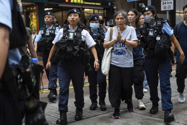 Activist Lui Yuk-lin, center right, is detained by police officers in the Causeway Bay area on the 36th anniversary of China's Tiananmen Square crackdown, in Hong Kong, Wednesday, June 4, 2025. The activist was stopped at a subway station in Causeway Bay and brought to a police van. It wasn't clear if she had been arrested. (AP Photo/Chan Long Hei)