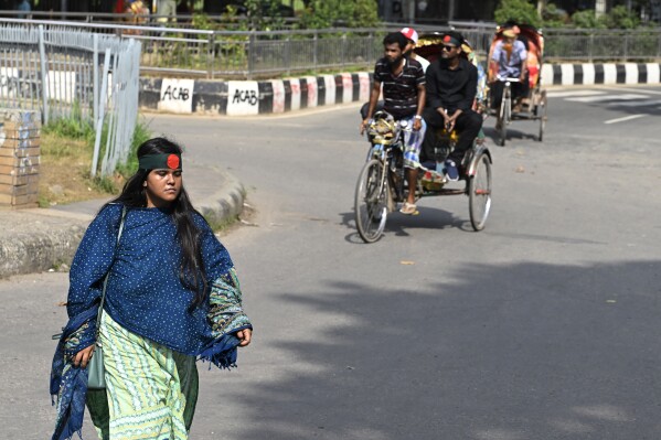 Nourin Sultana Toma, a student at Dhaka University, crosses a street to reach the university campus, in Dhaka, Bangladesh, Saturday, Aug. 10, 2024. (AP Photo/Fatima Tuj Johora)
