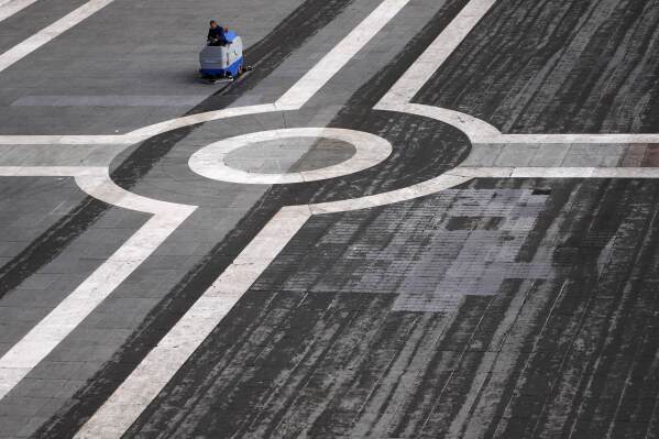A worker cleans the St. Peter's Square where 133 cardinals are gathering on the second day of the conclave to elect successor of late Pope Francis, at the Vatican, Thursday, May 8, 2025. (AP Photo/Gregorio Borgia)