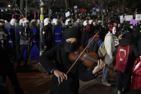 Một người biểu tình chơi đàn violin trong cuộc biểu tình sau khi Thị trưởng Istanbul Ekrem Imamoglu bị bắt và bị đưa vào tù, tại Istanbul, Thổ Nhĩ Kỳ, thứ Ba, ngày 25 tháng 3 năm 2025. (Ảnh AP/Khalil Hamra)