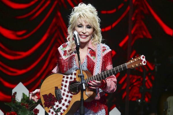 FILE - Dolly Parton performs at Austin City Limits Live during Blockchain Creative Labs' Dollyverse event during the South by Southwest Music Festival on Friday, March 18, 2022, in Austin, Texas. Parton laughs at the idea that she is some sort of secret philanthropist. “I don’t do it for attention,” she told The Associated Press in an interview, shortly before she received the Carnegie Medal of Philanthropy at Gotham Hall in New York City Thursday, Oct. 13, 2022.  (Photo by Jack Plunkett/Invision/AP, File)