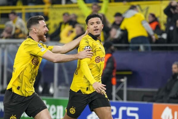 Dortmund's Jadon Sancho, right, celebrates with Dortmund's Salih Ozcan after scoring his side's opening goal during the Champions League round of 16 second leg soccer match between Borussia Dortmund and PSV Eindhoven at the Signal Iduna Park in Dortmund, Germany, Wednesday, March 13, 2024. (AP Photo/Martin Meissner)