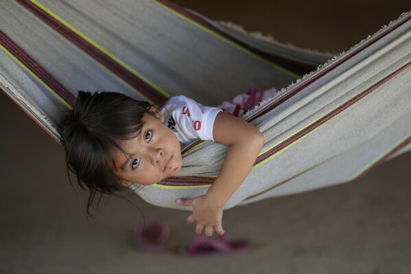 An Indigenous Juma girl rests in a hammock at her community, near Canutama, Amazonas state, Brazil, Sunday, July 9, 2023. The Juma seemed destined to disappear following the death of the last remaining elderly man, but under his three daughters’ leadership, they changed the patriarchal tradition and now fight to preserve their territory and culture. (AP Photo/Andre Penner)