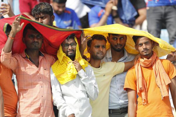 FILE - Cricket fans cover their heads with a long scarf to shield themselves from heat during an Indian Premier League (IPL) cricket match in Lucknow, India, April 22, 2023. A searing heat wave in parts of southern Asia in April this year was made at least 30 times more likely by climate change, according to a rapid study by international scientists released Wednesday, May 17. (AP Photo/Surjeet Yadav, File)