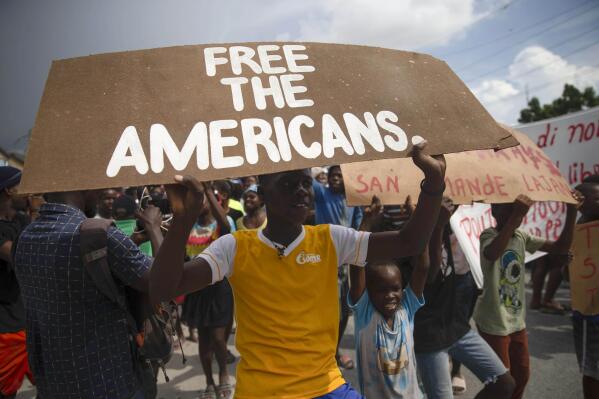People protest for the release of kidnapped missionaries near the Ohio-based Christian Aid Ministries headquarters in Titanyen, north of Port-au-Prince, Haiti, Tuesday, Oct. 19, 2021. A group of 17 U.S. missionaries including children was kidnapped by a gang in Haiti on Saturday, Oct. 16, according to a voice message sent to various religious missions by an organization with direct knowledge of the incident. (AP Photo/Joseph Odelyn)