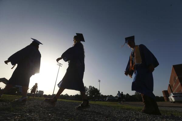 FILE - In this June 27, 2020, file photo, Saltillo High School seniors make their way to the football field as the sun begins to set for their graduation ceremony in Saltillo, Miss. Federal parent PLUS loans have become a last resort for many lower-income families paying for a kid’s college education. Today, parent PLUS loan debt totals $108.5 billion among 3.7 million borrowers, and the average borrower owes more than $29,000. (Thomas Wells/The Northeast Mississippi Daily Journal via AP, File)