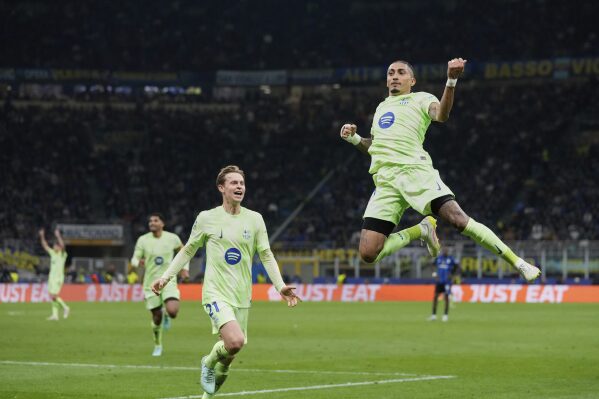 Barcelona's Raphinha, right, celebrates after scoring his side's third goal during the Champions League semifinal second leg soccer match between Inter Milan and Barcelona at San Siro stadium in Milan , Italy, Tuesday, May 6, 2025. (AP Photo/Luca Bruno)