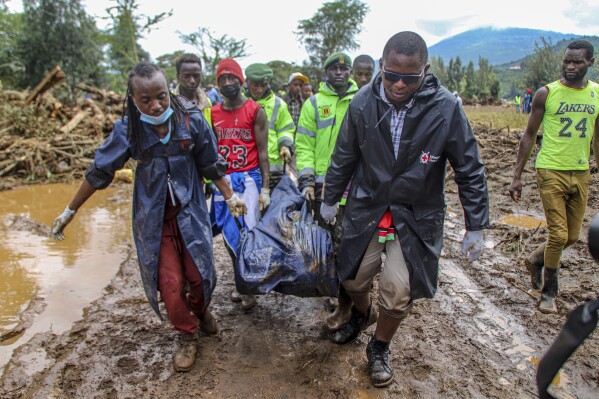 FILE - Operatori e volontari della Croce Rossa del Kenya trasportano il corpo di un uomo dopo che le case sono state spazzate via dalle acque alluvionali, nel villaggio di Kamuchiri Mai Mahiu, contea di Nakuru, Kenya, il 30 aprile 2024. In un mondo sempre più abituato ai capricci del clima selvaggio , gli ultimi giorni e settimane sembrano aver... Questi estremi ambientali sono stati portati a un nuovo livello.  (Foto AP/Patrick Ngugi, file)