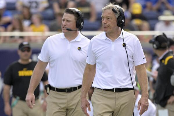 FILE - Iowa head coach Kirk Ferentz, right, and offensive coordinator Brian Ferentz walk along the sideline during the first half of the Citrus Bowl NCAA college football game against Kentucky, Saturday, Jan. 1, 2022, in Orlando, Fla. A propensity to pass down the family business often stokes a passion to follow in Dad's footsteps, but it has also helped perpetuate a lack of racial and ethnic diversity at the highest levels of football coaching.(AP Photo/Phelan M. Ebenhack, File)