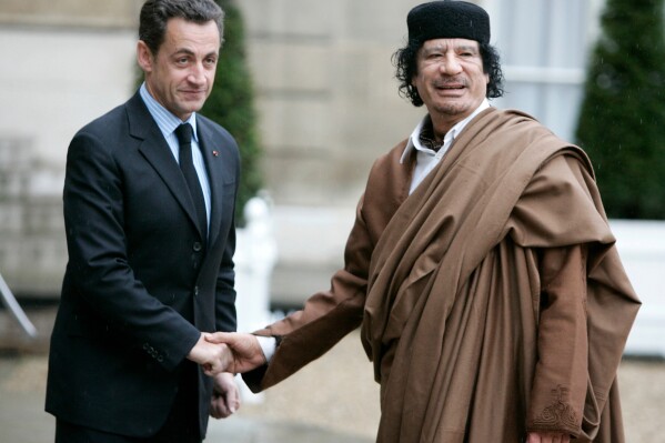 FILE - French President Nicolas Sarkozy, left, greets Libyan leader Col. Moammar Gadhafi upon his arrival at the Elysee Palace, Dec. 10 2007 in Paris. French investigative judges have filed Friday Oct.6, 2023 preliminary charges against former President Nicolas Sarkozy for his alleged involvement in an attempt to mislead magistrates in order to clear him in a case regarding the suspected illegal financing from Libya of his 2007 presidential campaign. (AP Photo/Francois Mori, File)