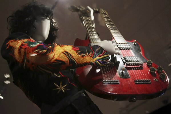 
              This April 1, 2019 file photo shows a double-neck guitar played by Jimmy Page of Led Zeppelin displayed at the exhibit "Play It Loud: Instruments of Rock & Roll," at the Metropolitan Museum of Art in New York. The exhibit, which showcases the instruments of rock and roll legends, runs until Oct. 1, 2019. (AP Photo/Seth Wenig, File)
            