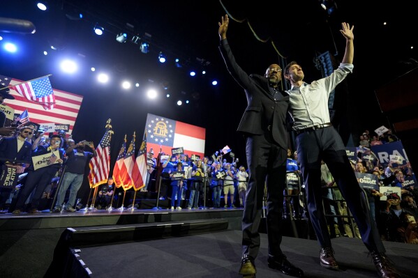 U.S. Sens. Raphael Warnock, D-Ga., left, and Jon Ossoff, D-Ga., wave to the crowd during a Rally for our Republic gathering, Saturday, March 22, 2025, in Atlanta. (AP Photo/Mike Stewart)