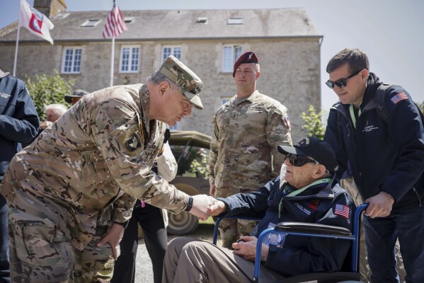 FILE - U.S. Gen. Mark Milley, left, shakes hands with Tec4 Moshe D. Lenske during a gathering in preparation of the 79th D-Day anniversary in La Fiere, Normandy, France, Sunday, June 4, 2023. The landings on the coast of Normandy 79 year ago by U.S. and British troops took place on June 6, 1944. (AP Photo/Thomas Padilla, File)