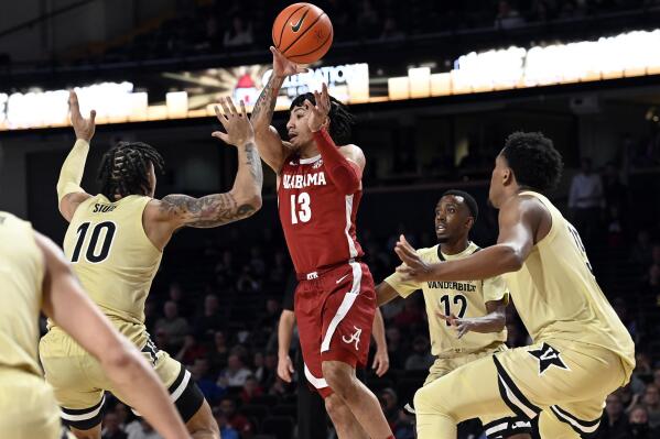 Alabama guard Jahvon Quinerly (13) passes the ball in front of Vanderbilt forward Myles Stute (10) during the second half of an NCAA college basketball game Tuesday, Feb. 22, 2022, in Nashville, Tenn. (AP Photo/Mark Zaleski)