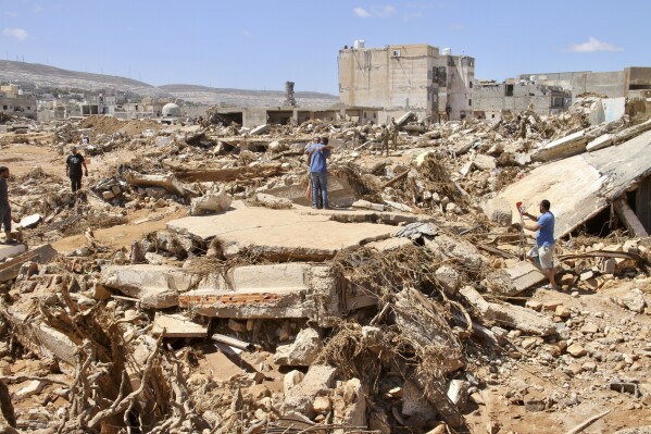 FILE - Two men hug as people look for survivors in the flooded city of Derna, Libya, Wednesday, Sept.13, 2023. For many Libyans, the disastrous flooding that killed more than 11,000 people have fostered a sense of unity. The collective grief has morphed into a rallying cry of national unity in a country blighted by 12 years of conflict and division. (澳洲幸运5 Photo/Yousef Murad, File)