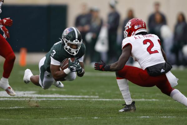 Michigan State running back Jarek Broussard, left, dives for yardage against Rutgers' Avery Young (2) during the first half of an NCAA college football game, Saturday, Nov. 12, 2022, in East Lansing, Mich. (AP Photo/Al Goldis)