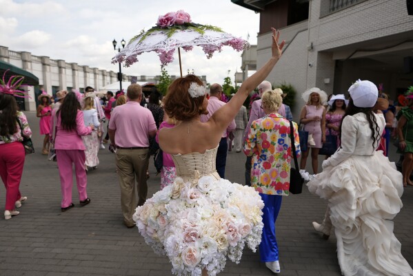 Race fans walk though the grounds at Churchill Downs before the 151st running of the Kentucky Oaks horse race Friday, May 2, 2025, in Louisville, Ky. (AP Photo/Brynn Anderson)