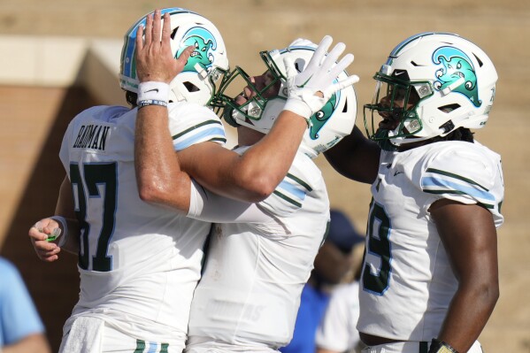 Tulane tight end Alex Bauman, left, celebrates his touchdown with quarterback Michael Pratt, center, and tight end Reggie Brown during the first half of an NCAA college football game against Rice, Saturday, Oct. 28, 2023, in Houston. (AP Photo/Eric Christian Smith)