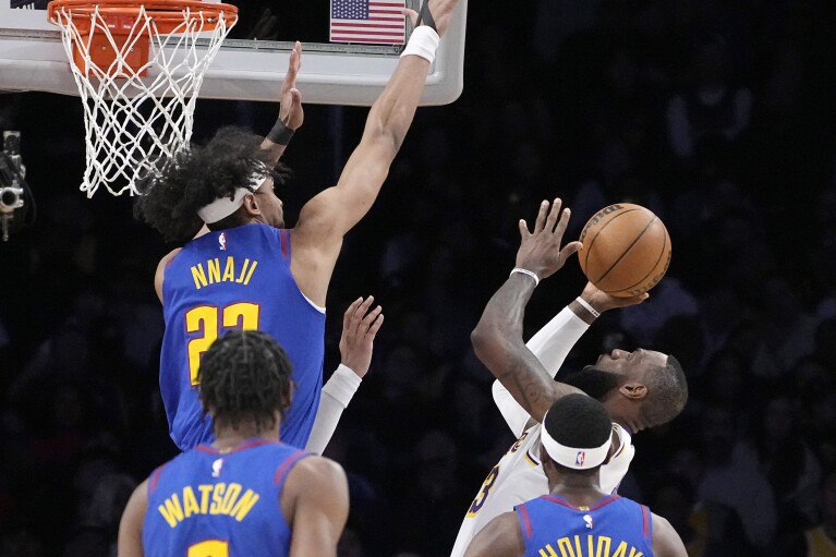 Los Angeles Lakers forward LeBron James, right, shoots as Denver Nuggets forward Zeke Nnaji, left, forward Peyton Watson, second from left, and forward Justin Holiday defend during the first half of an NBA basketball game Saturday, March 2, 2024, in Los Angeles. (AP Photo/Mark J. Terrill)