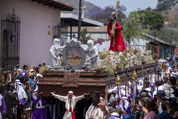 Penitents knows as cucuruchos carry a religious float transporting a 300-year-old, life-sized statue of Jesus Christ bearing the cross, during a Holy Week procession in Antigua, Guatemala, on Good Friday, March 29, 2024. (AP Photo/Moises Castillo)