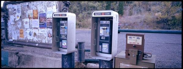 Two disconnected pay phones stand near the post office in Bisbee, Ariz., Oct. 26, 2021. In 1995, The Church of Jesus Christ of Latter-day Saints established a “help line” for bishops and other church leaders seeking guidance on reporting allegations of child sexual abuse. But help line calls are often referred to a law firm that represents the church and is responsible for alerting the church to potentially costly sexual abuse lawsuits. In the case of Paul Adams, who repeatedly raped his two daughters, a bishop called the help line and was told to keep the abuse secret, because Adams admitted to the abuse during confession. (AP Photo/Dario Lopez-Mills)