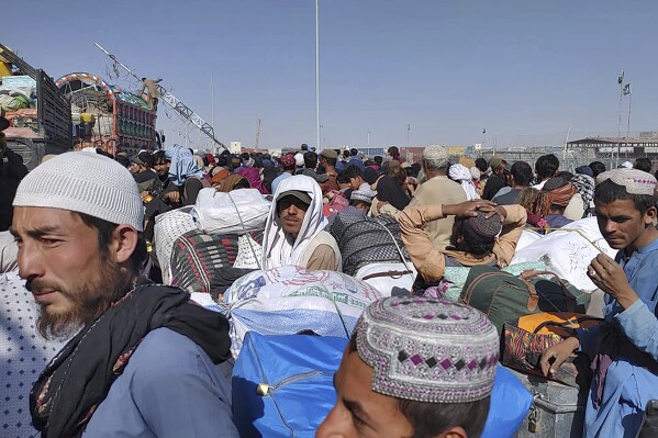 Afghans wait to walk across a border crossing point in Chaman, Pakistan, Tuesday, Oct. 31, 2023. A large number of Afghans crammed into trucks and buses in Pakistan, heading to the border to return home hours before the expiration of a Pakistani government deadline for those who are in the country illegally to leave or face deportation. (AP Photo/Jafar Khan)