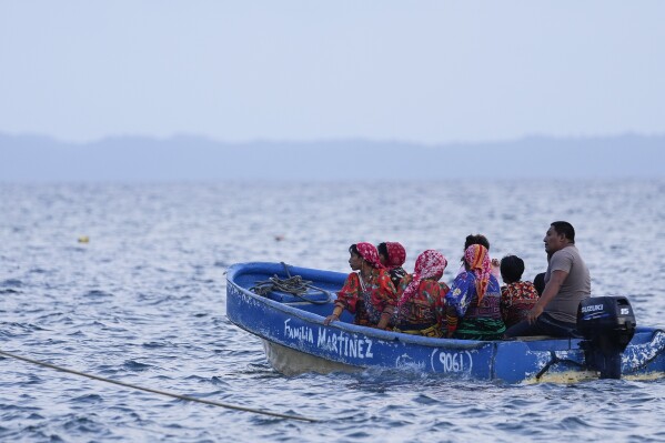 Residents from Gardi Sugdub Island use a boat to reach the mainland, in the San Blas archipelago off Panama's Caribbean coast, Monday, May 27, 2024. Due to rising sea levels, about 300 Guna Indigenous families will relocate to new homes, built by the government, on the mainland. (AP Photo/Matias Delacroix)